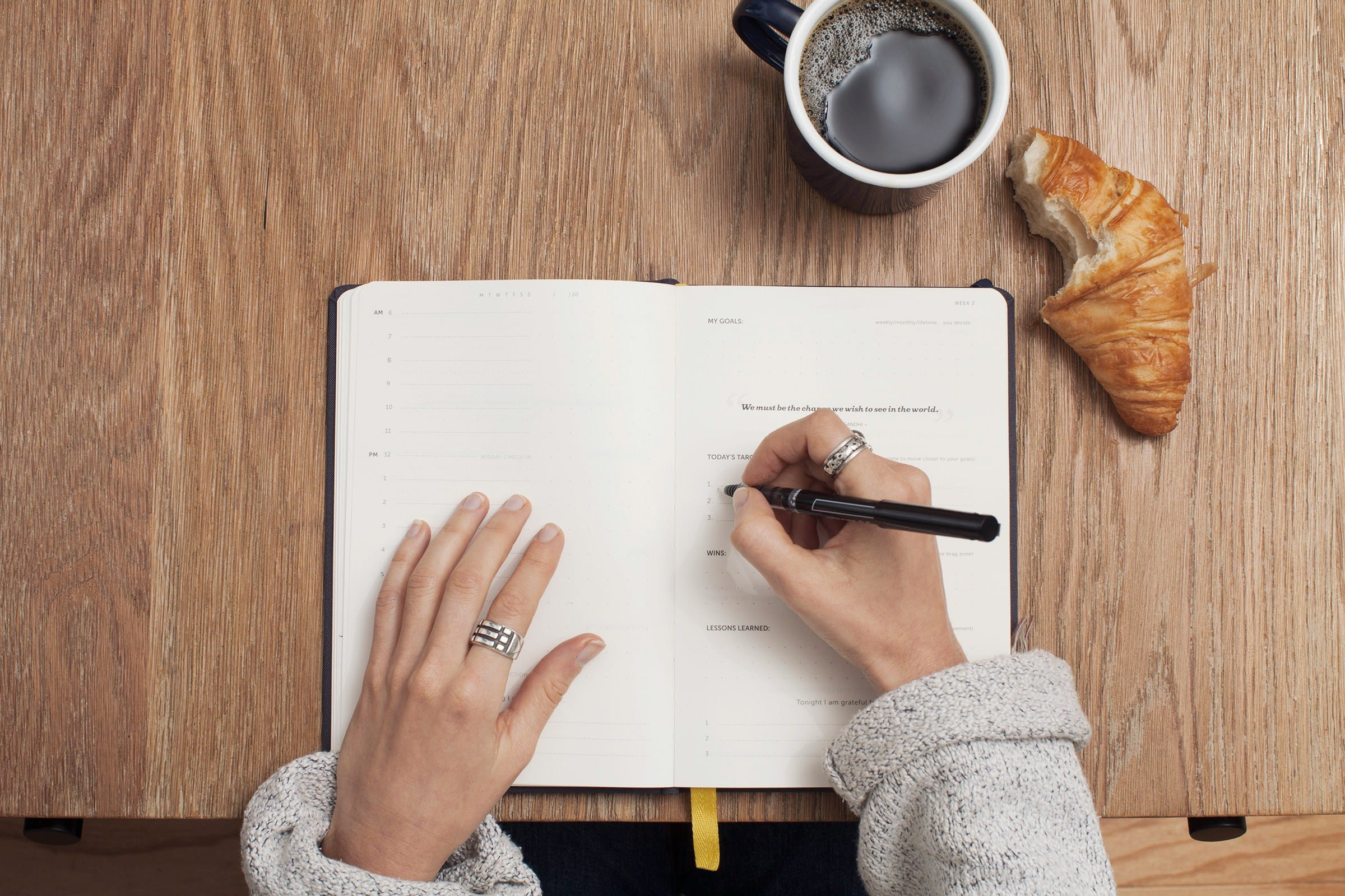 Female writing in their diary planner with a cup of coffee